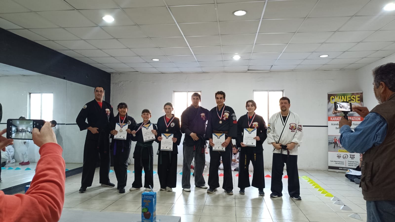 Alumnos recibiendo sus certificados de grado junto a los instructores
